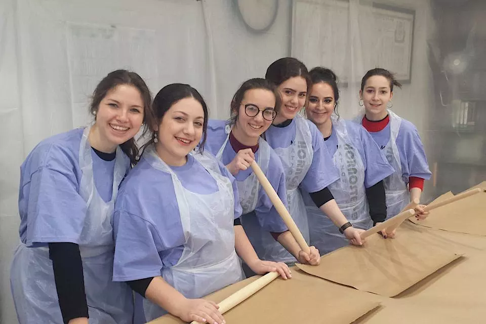 A group of women in aprons holding rolling pins.